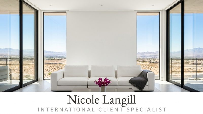 Modern living room with a white sofa, purple flowers, and large windows overlooking a desert landscape.