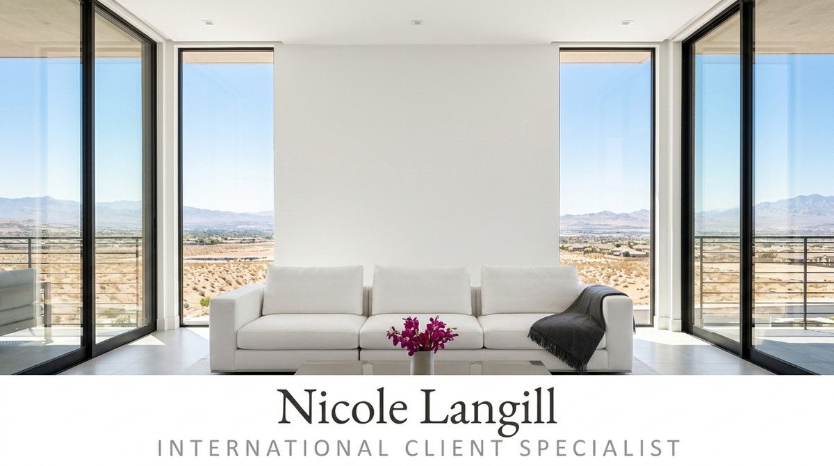 Modern living room with a white sofa, purple flowers, and large windows overlooking a desert landscape.